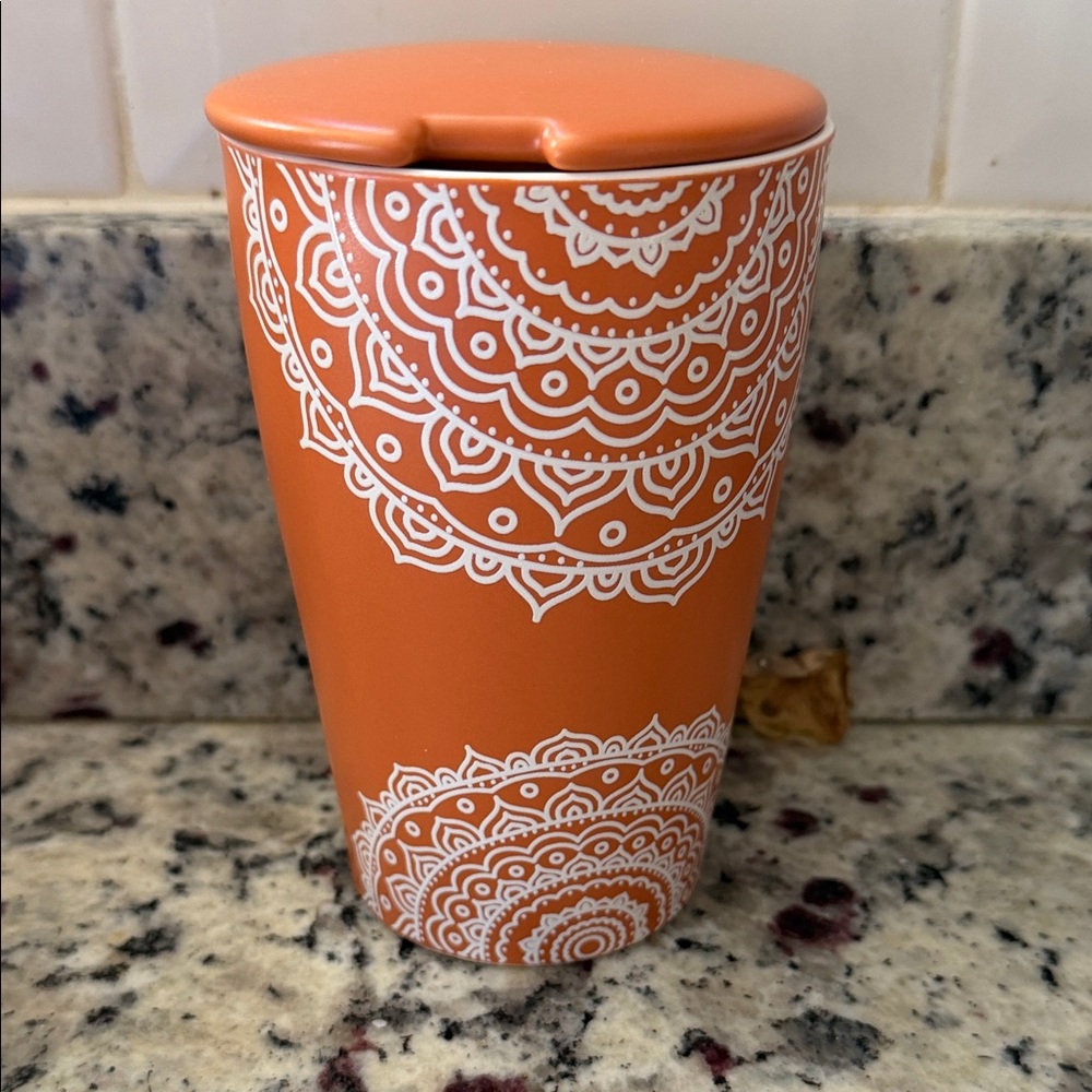 Vibrant Orange Travel Mug with Intricate White Design